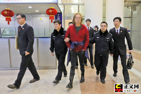 王某(中)走出機(jī)場(chǎng)后被辦案人員帶走,成為今年上海市首例經(jīng)勸返回國自首的外逃人員。